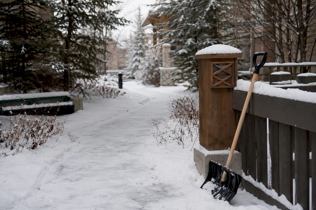 Snow-dusted HOA walkway with shovel stake