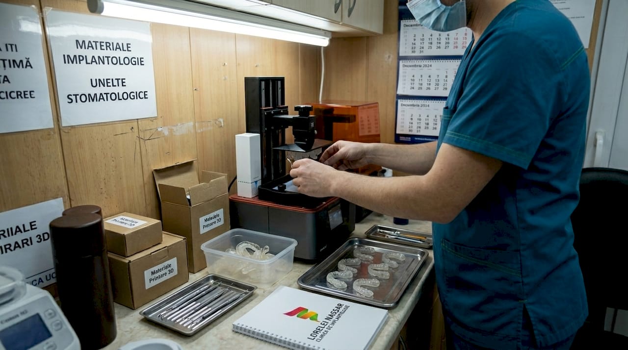 Cum te ajută tehnologia 3D în albirea dentară: ghid complet 1 Tehnicianul pregătește gutierele pentru albirea dinților folosind imprimanta 3D.