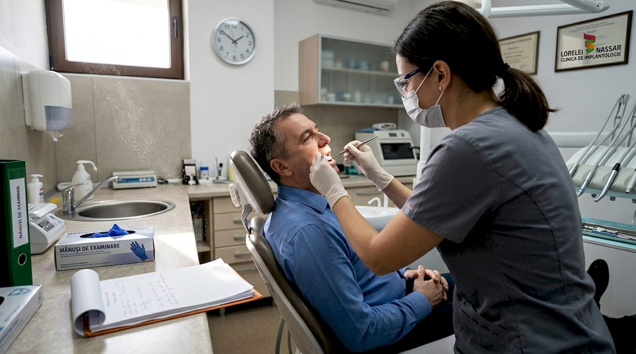 Igienistul dentar efectuează un control de rutină