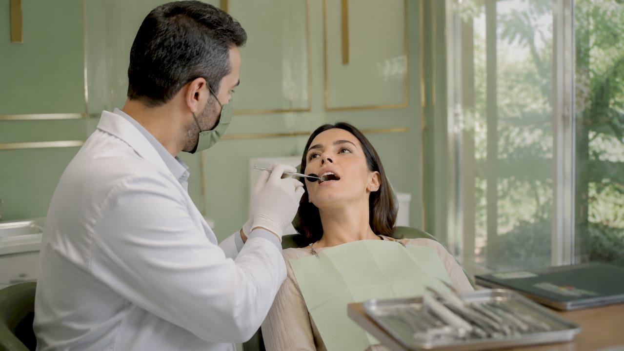 Medic stomatolog analizând atent dinții cu semne de uzură