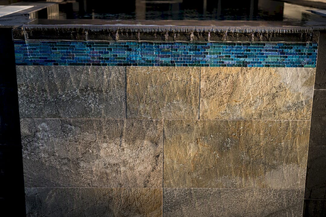 Glass tile band against stone spillway