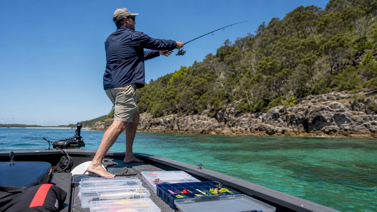 Angler fishing on boat in coastal waters morning