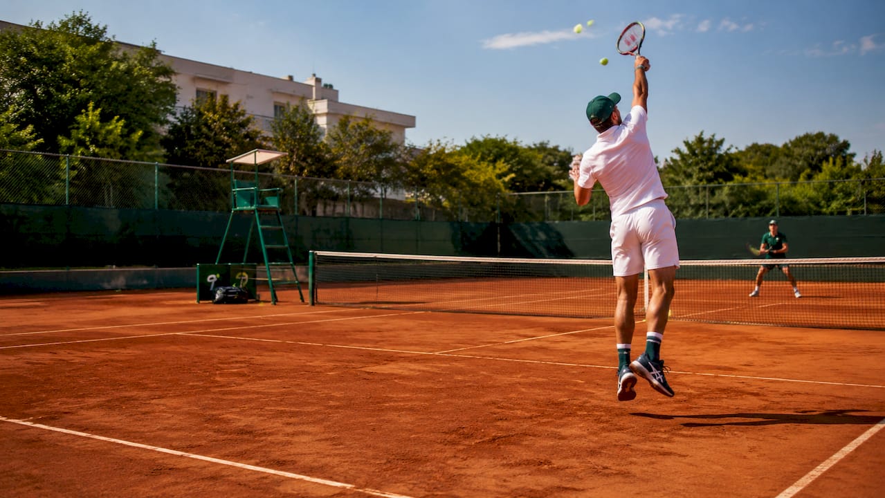 Overhead tennis match showing player pressure on court