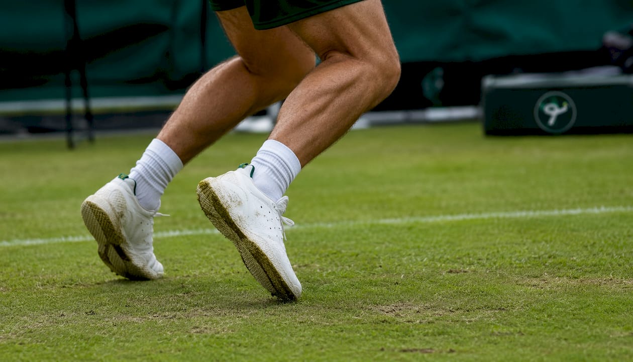 Tennis player footwork and shoes on grass