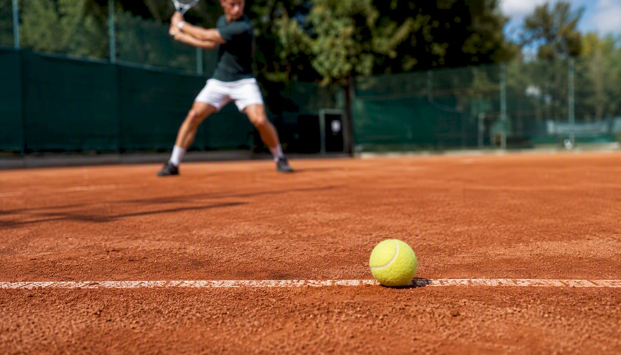 Tennis ball on clay court surface
