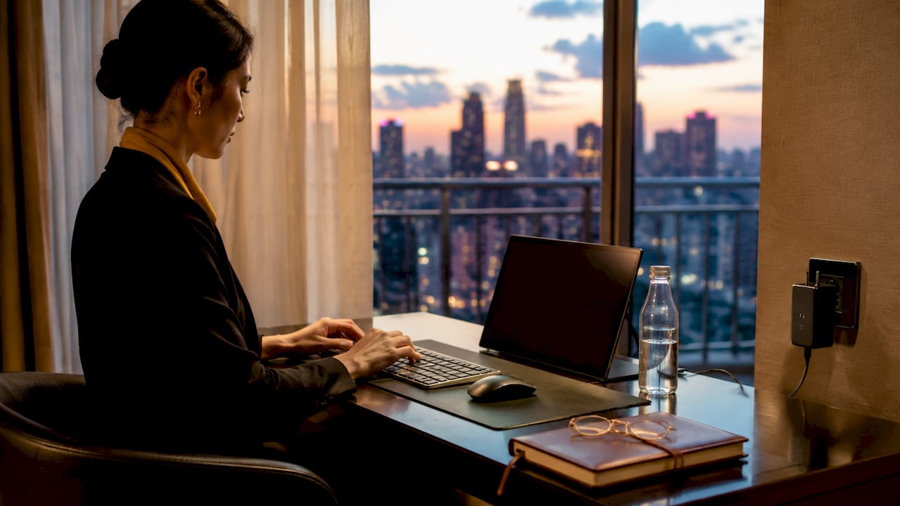 Hands typing on hotel ergonomic workspace setup