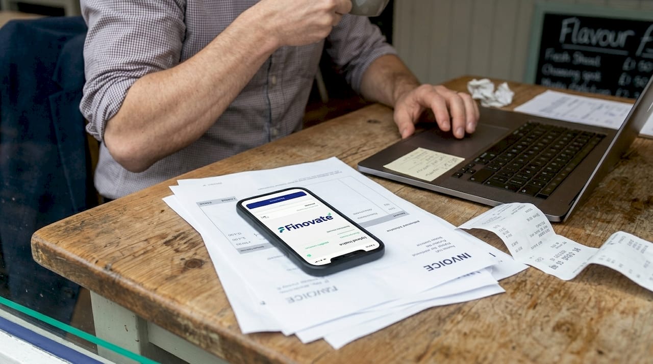 Man uploading digital invoice in café