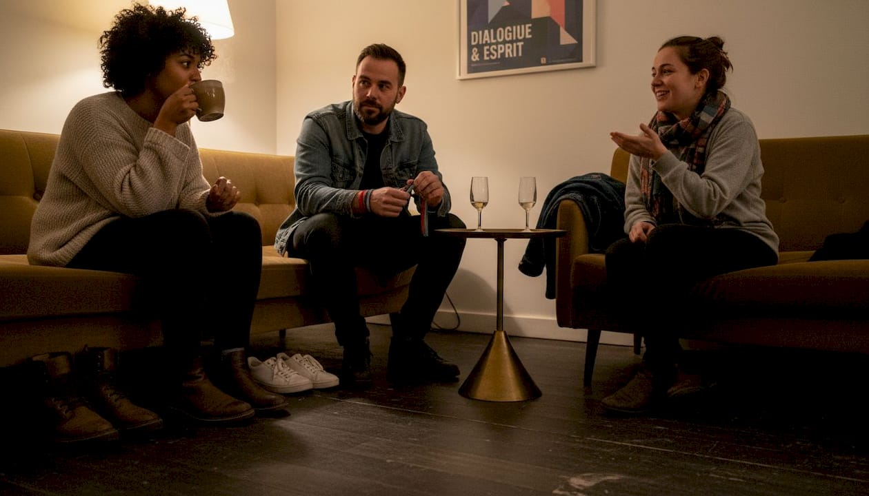 Un groupe varié échange et discute dans une ambiance conviviale lors d’un événement au lounge.