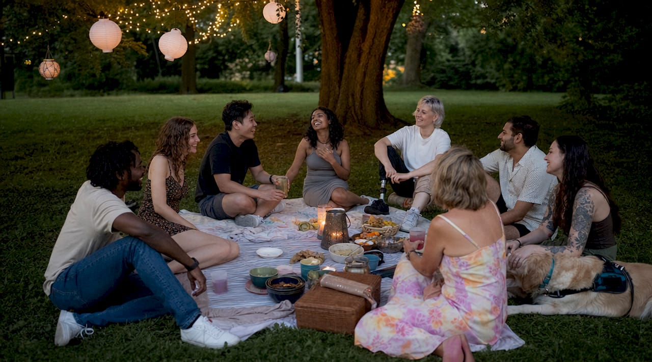 Des personnes de tous horizons se retrouvent en plein air lors d’un événement convivial organisé par la communauté.