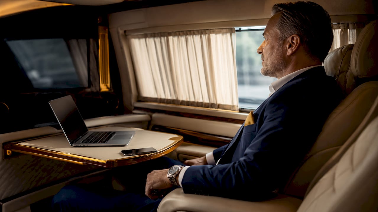 Executive enjoying privacy and comfort inside VIP limousine