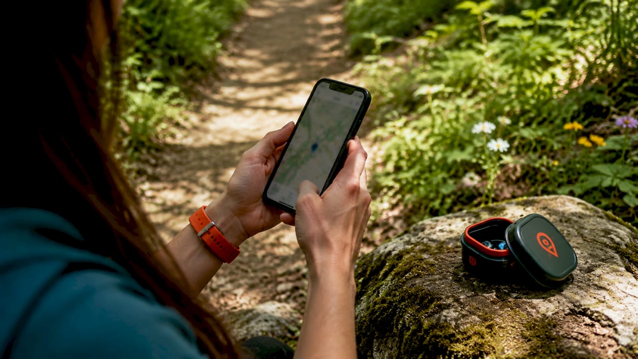 Eine Frau nutzt ihr Smartphone zur Navigation im Wald.