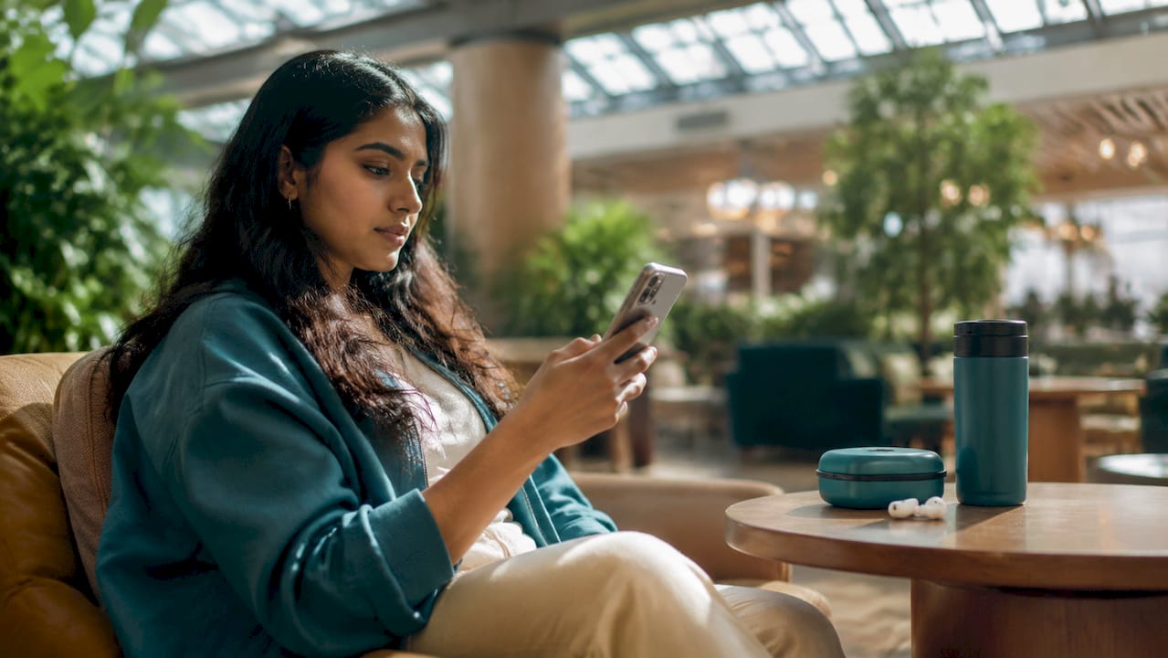 Traveler using smartphone with eSIM at airport cafe