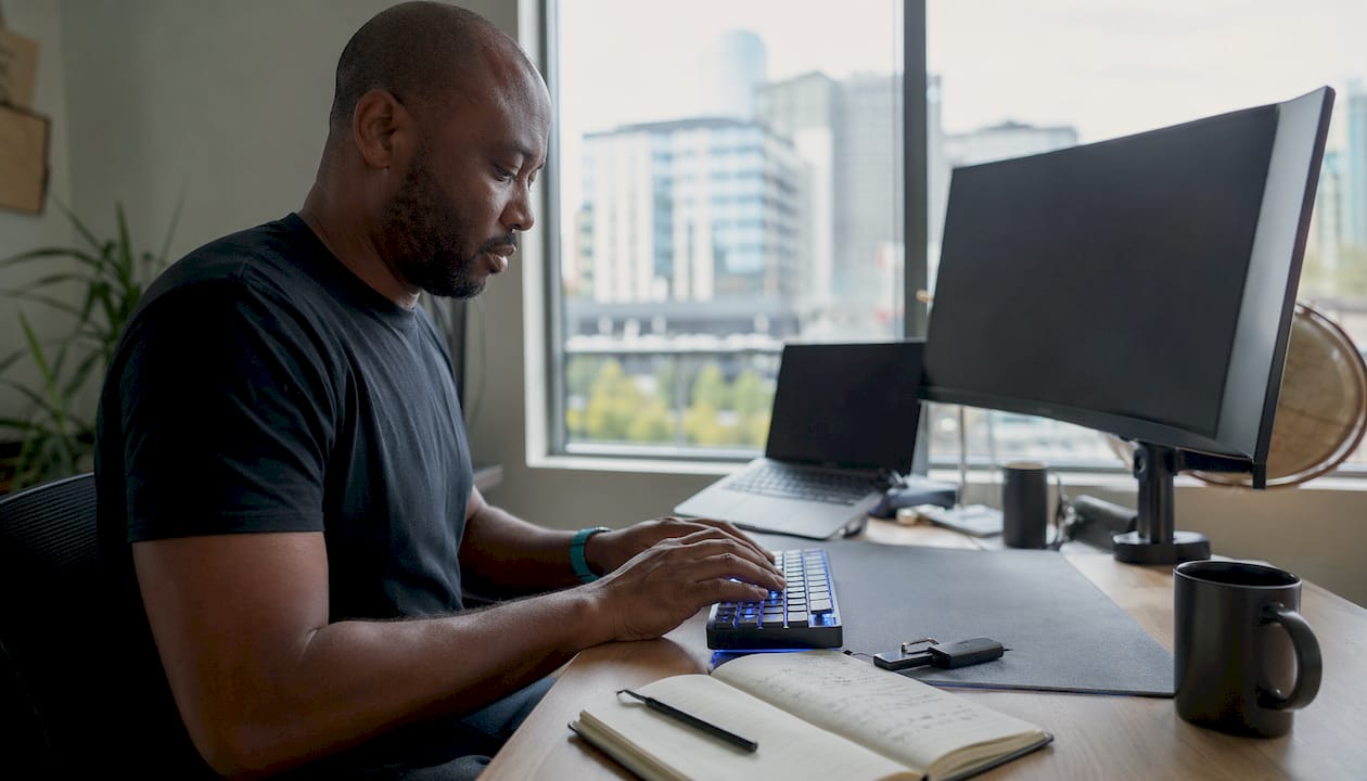 Hands on keyboard with crypto wallet nearby