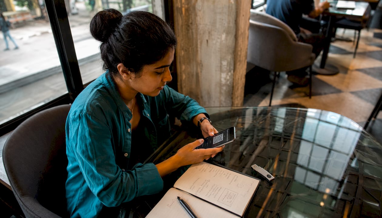 Woman using smartphone to scan crypto wallet address