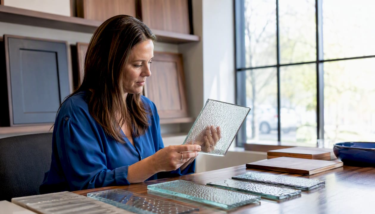 Designer choosing textured glass samples for cabinets