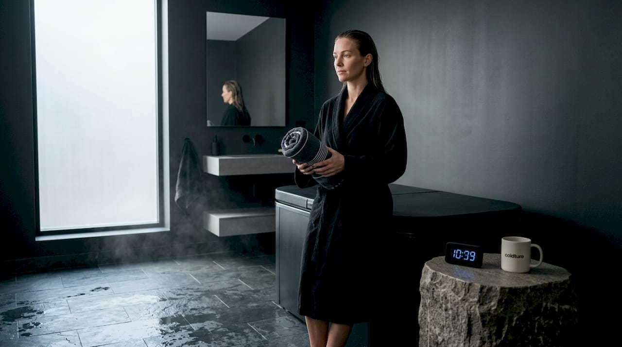 Woman doing post-plunge breathwork in bathroom