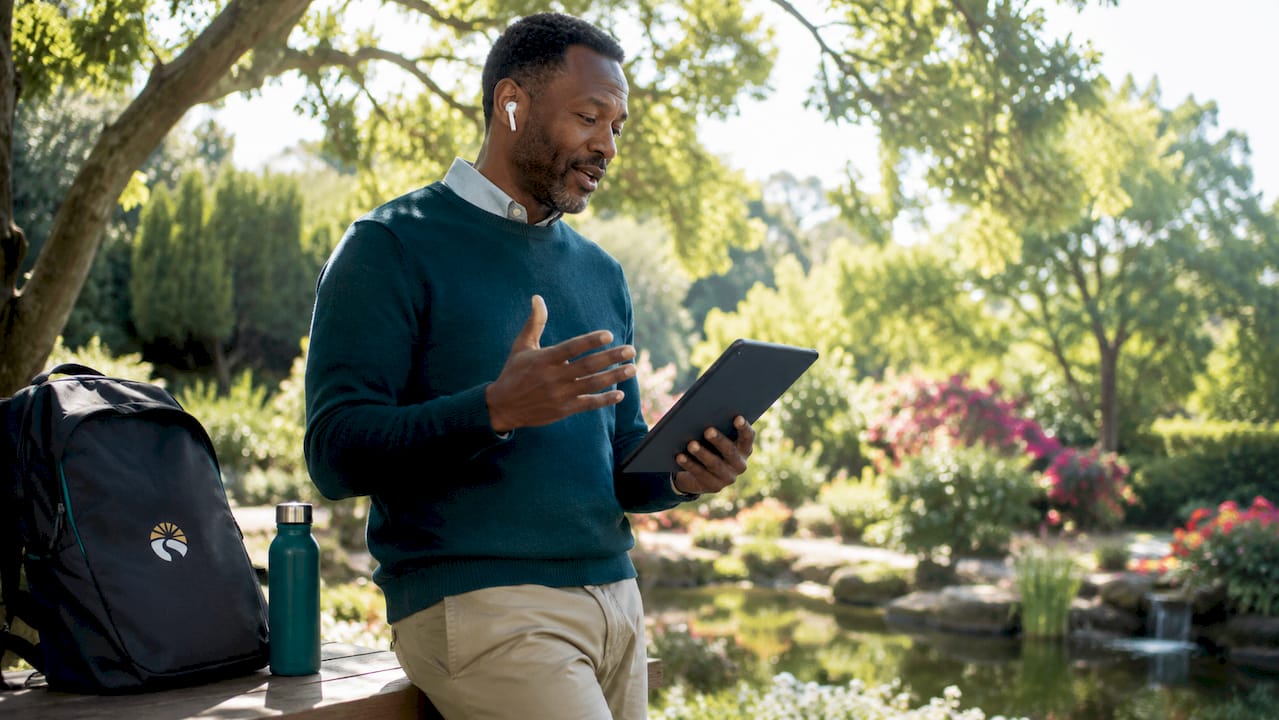 Man attending teletherapy outdoors on tablet
