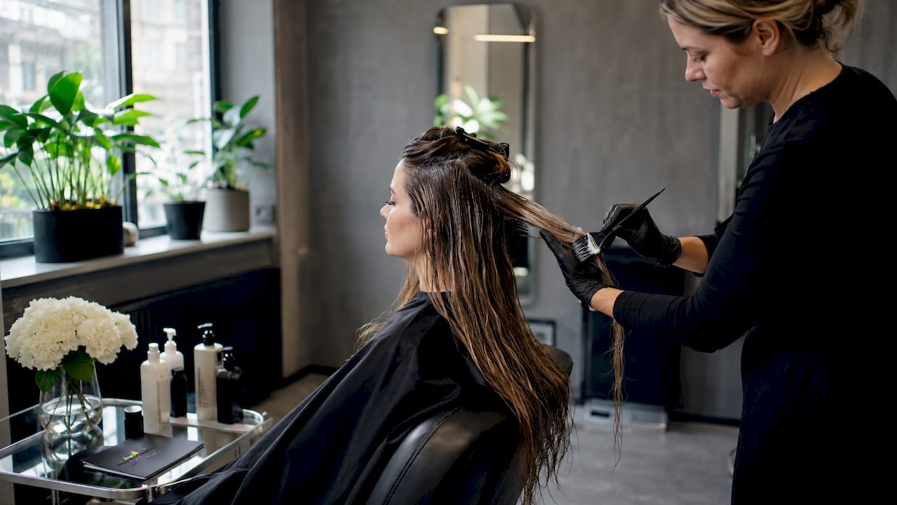 Eine Frau lässt sich im Friseursalon mit einer Haar-Botox-Behandlung verwöhnen.