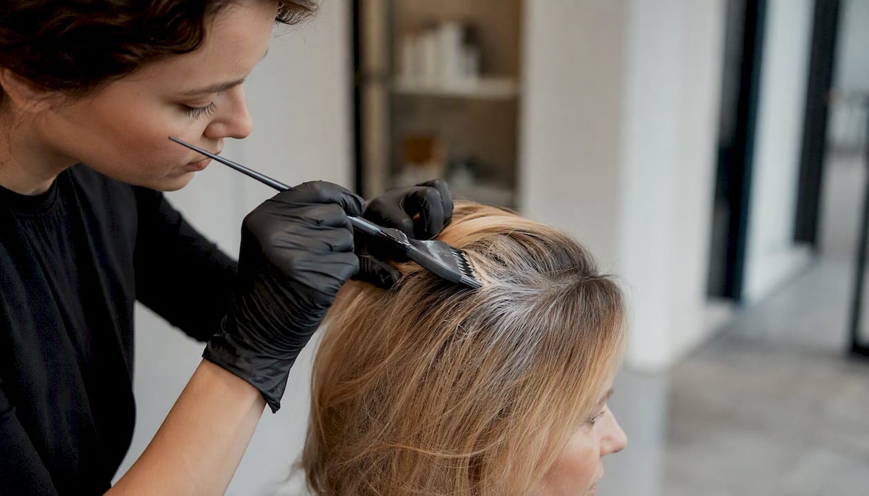 Nahaufnahme: Ein Friseur färbt graues Haar im Salon.