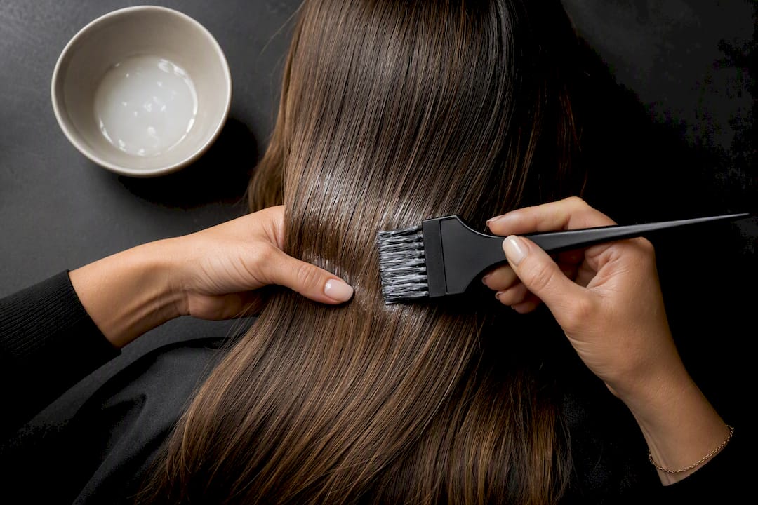 Friseurin bringt Glossing auf die Haarlängen auf