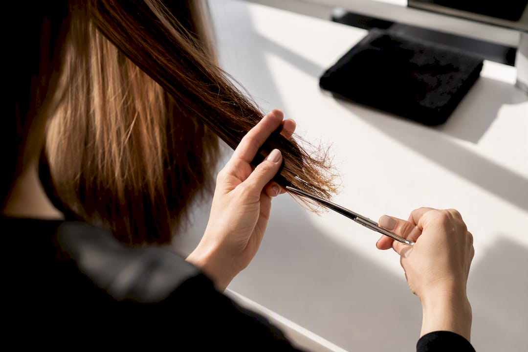 Friseurin schneidet brüchige Haarspitzen