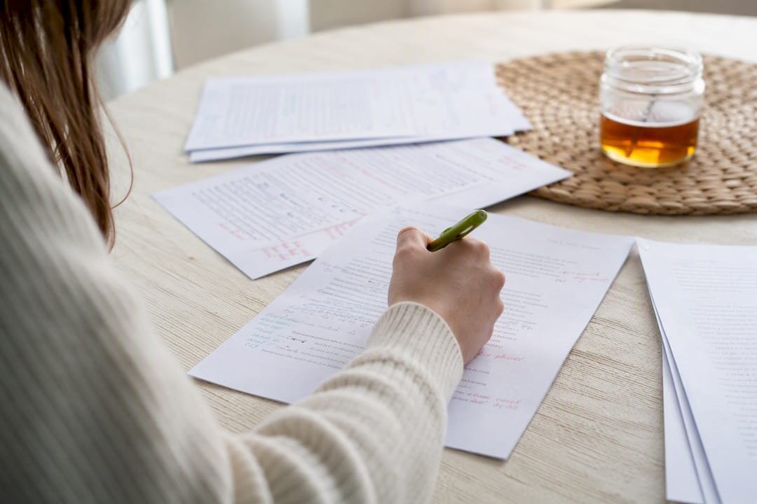 Hand editing essay drafts with annotations