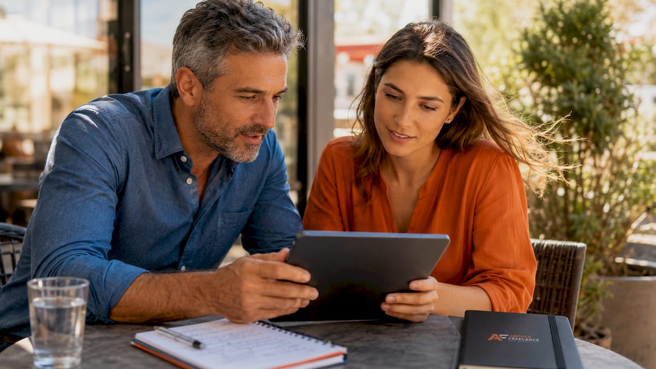 Due persone sedute al tavolino di un bar, mentre sfogliano le recensioni online e commentano le esperienze degli altri clienti.