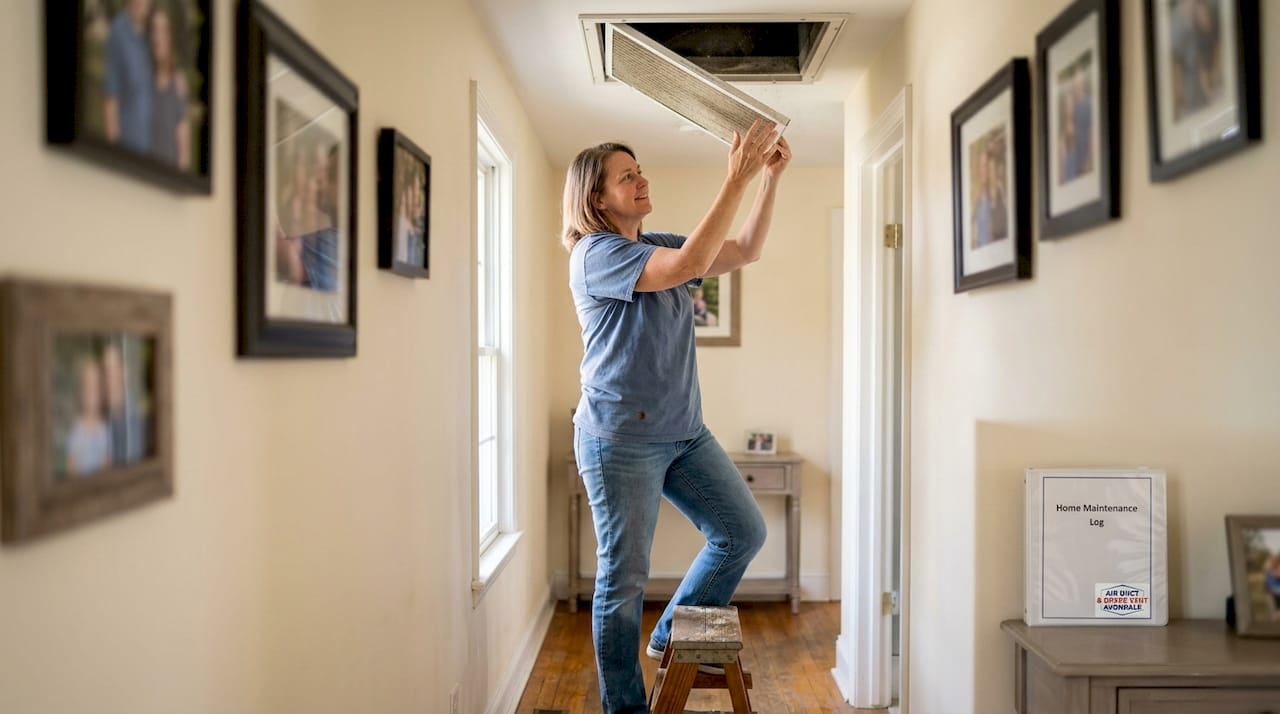 Homeowner changing ceiling HVAC filter