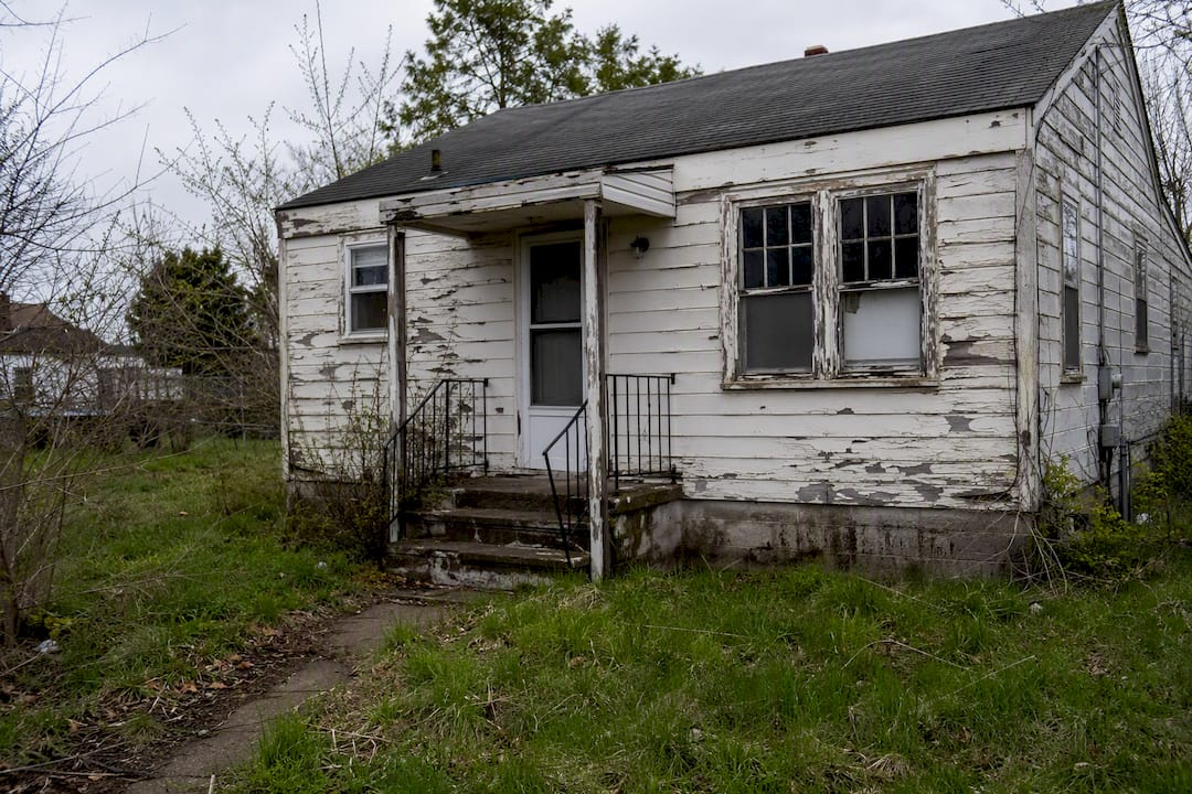 Worn house exterior with visible repair needs