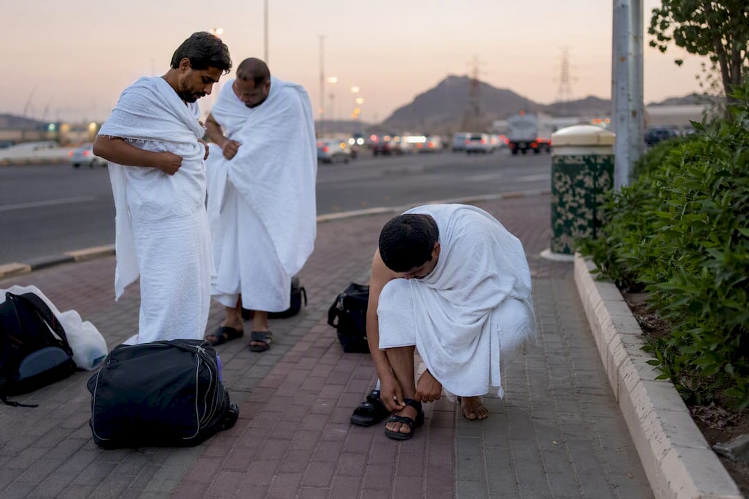 Pilgrim adjusting sandals at roadside rest