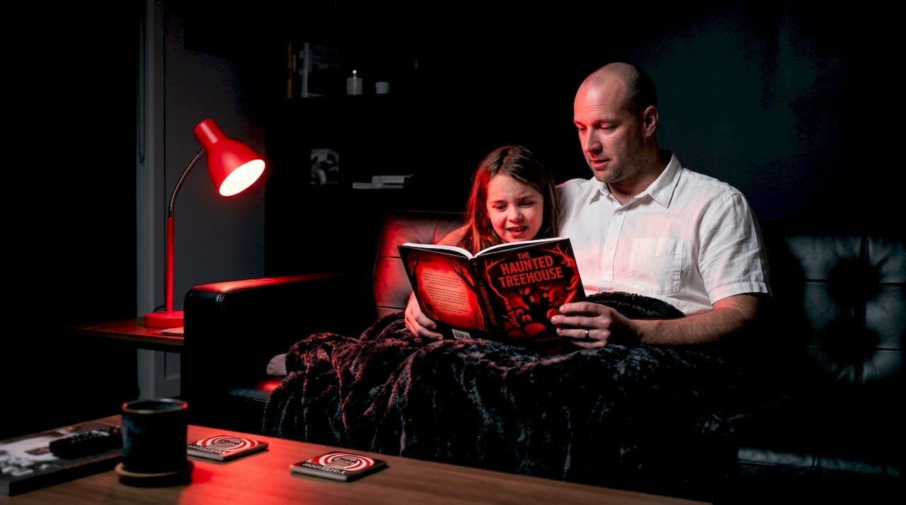 Parent and child reading scary book at home