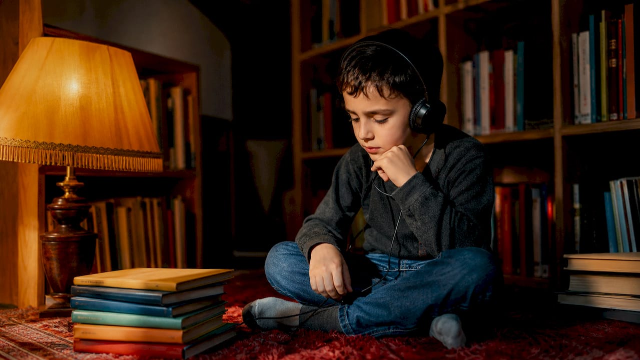 Child listening to audiobook with headphones