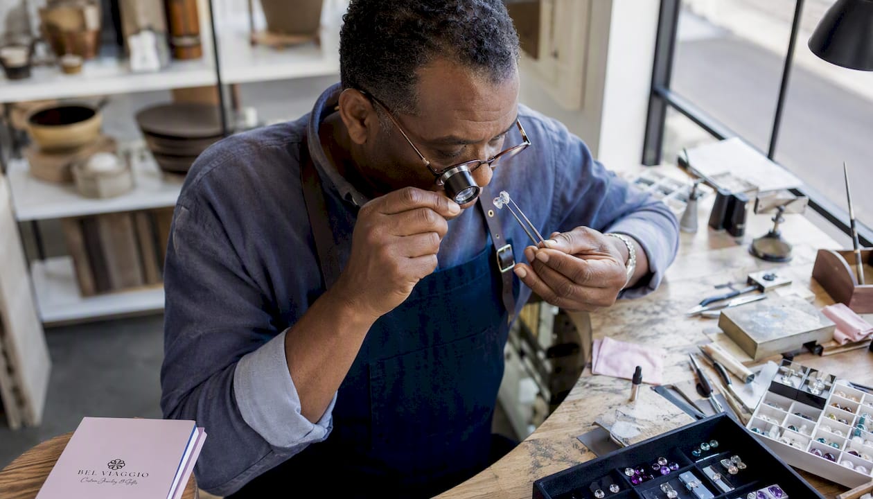 Jeweler inspecting diamond girdle in workshop