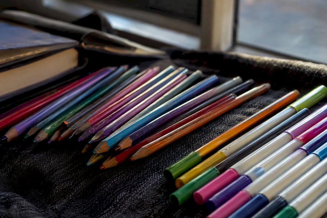 Colored pencils and markers laid out on surface
