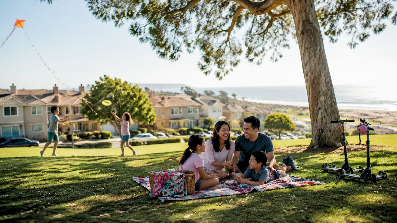 Family picnic in Torrance park under palm tree