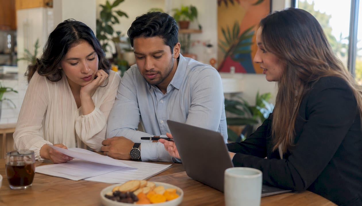 Couple consulting with local real estate agent indoors