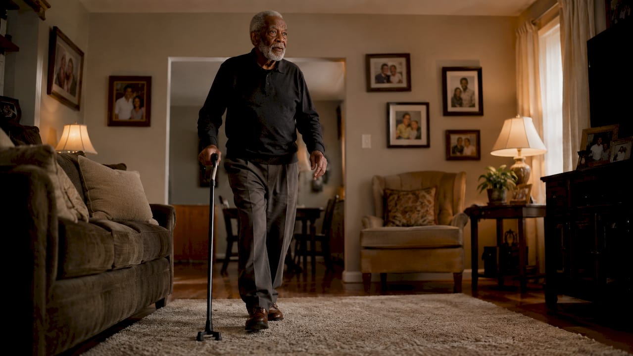 Elderly man using walking stick in kitchen