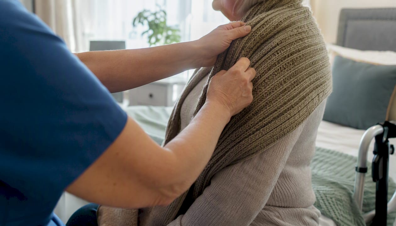 Carer assisting elderly person with hygiene