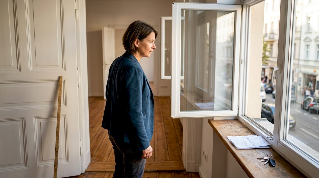 Eine Wohnungsbesitzerin überprüft, ob das Fenster offen ist.