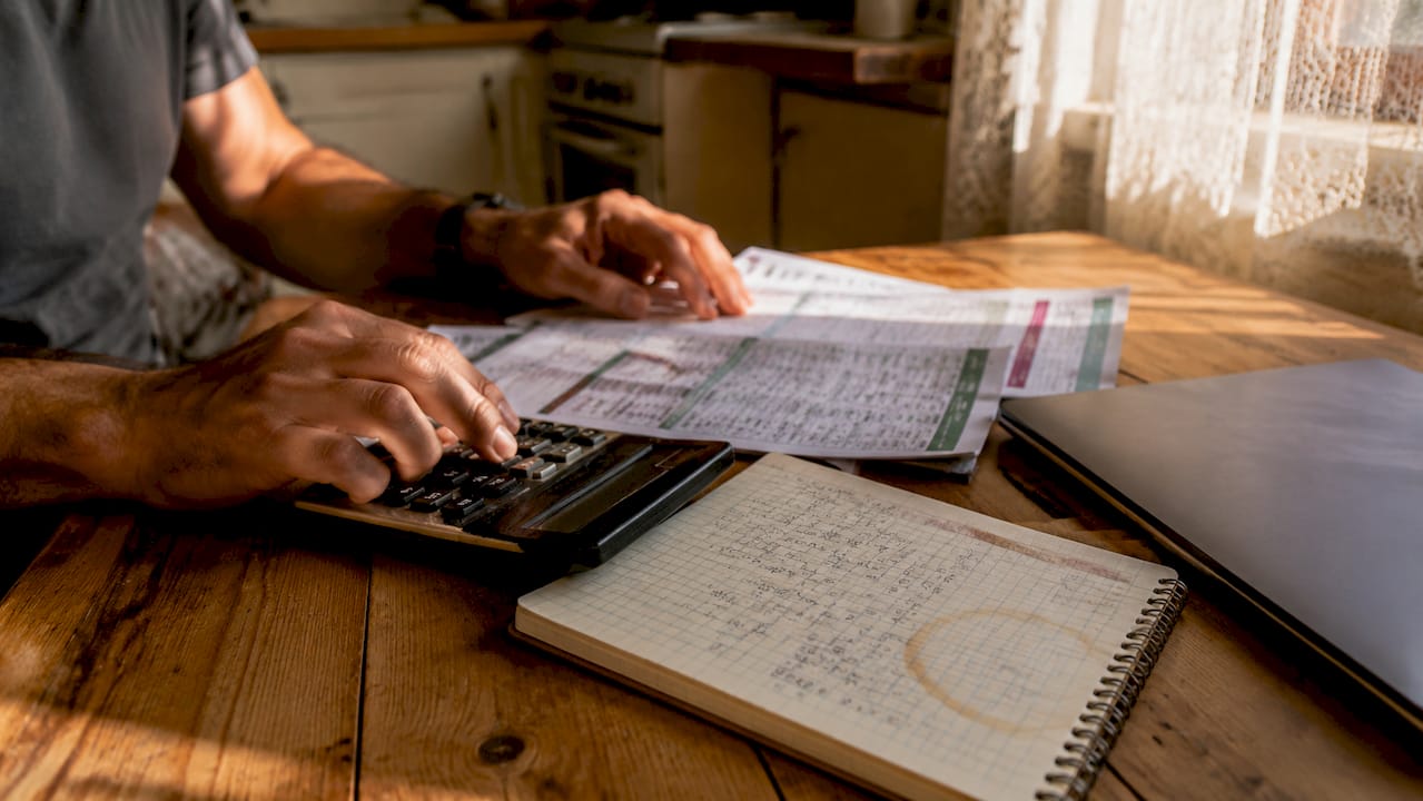 Hands calculating Forex broker lot sizes