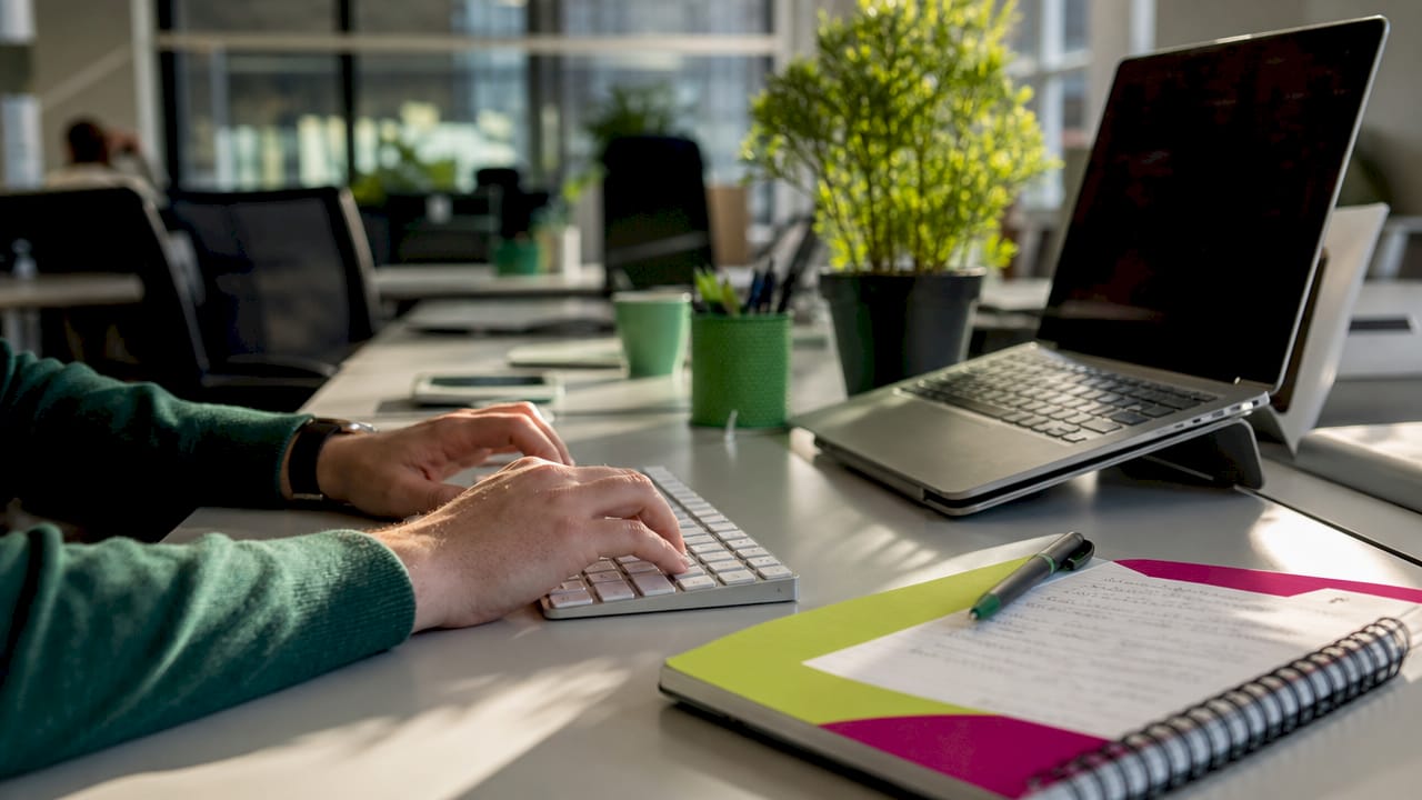 Hands typing on keyboard with financial documents