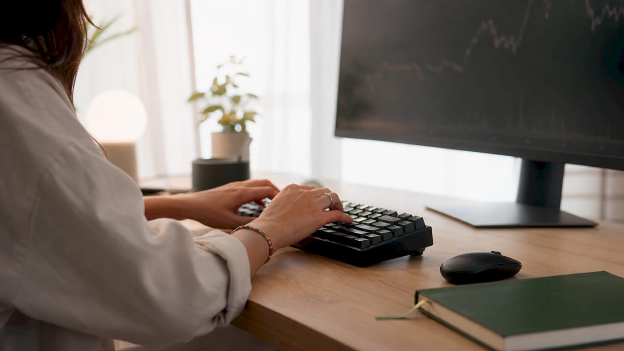 Prop trader at keyboard managing scaling