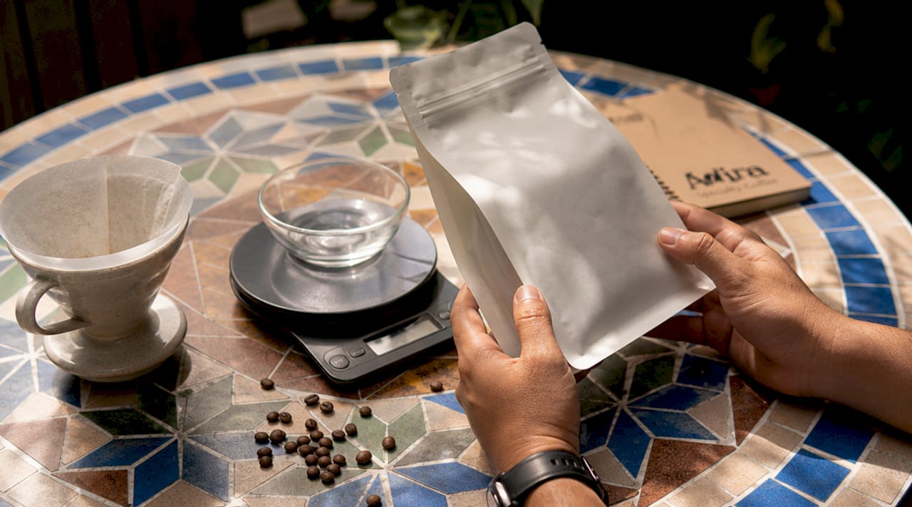 Hands inspecting specialty coffee bag and equipment