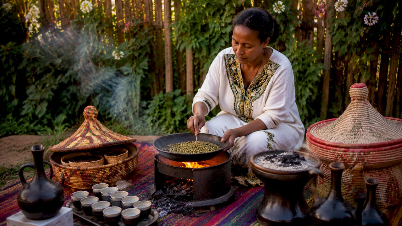 Woman conducting Ethiopian coffee ceremony outdoors