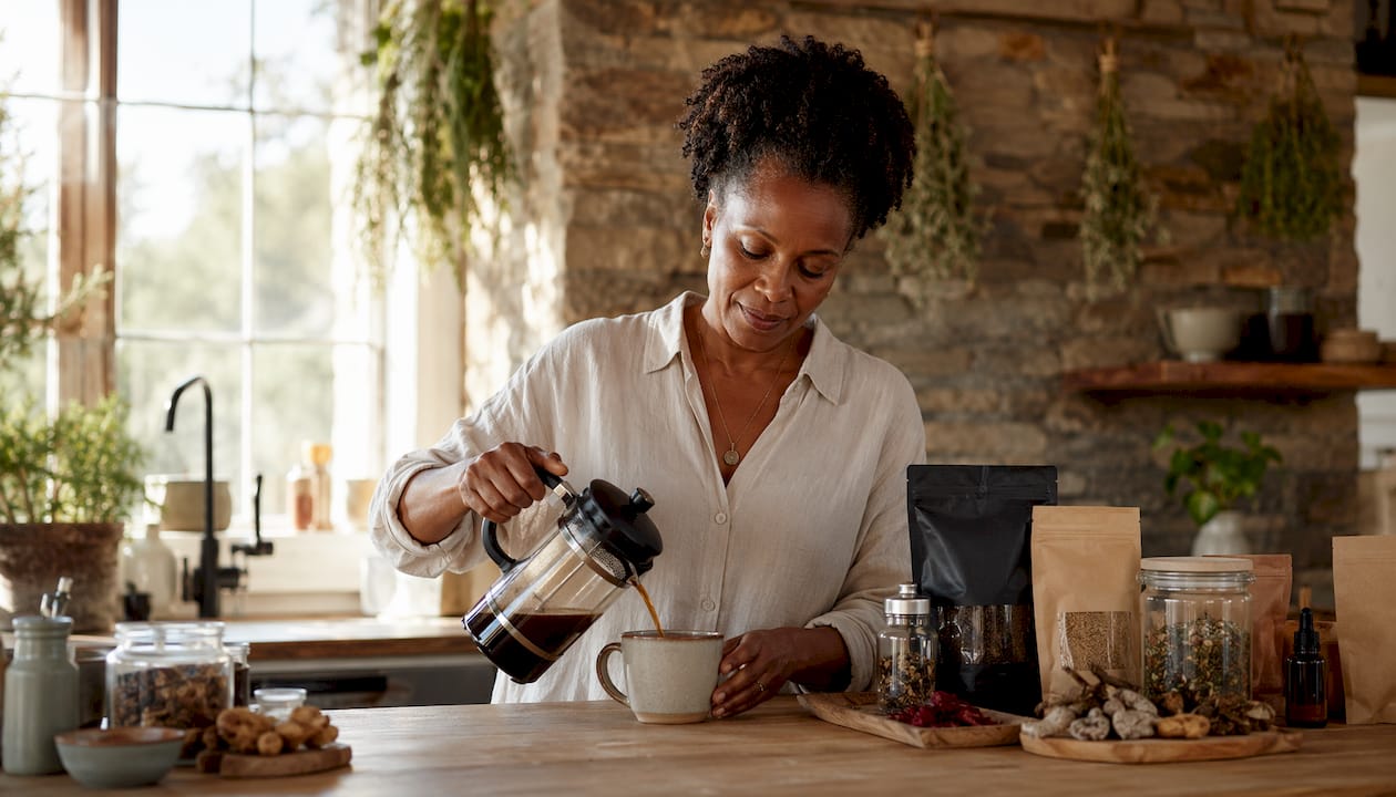Woman preparing mushroom coffee in kitchen