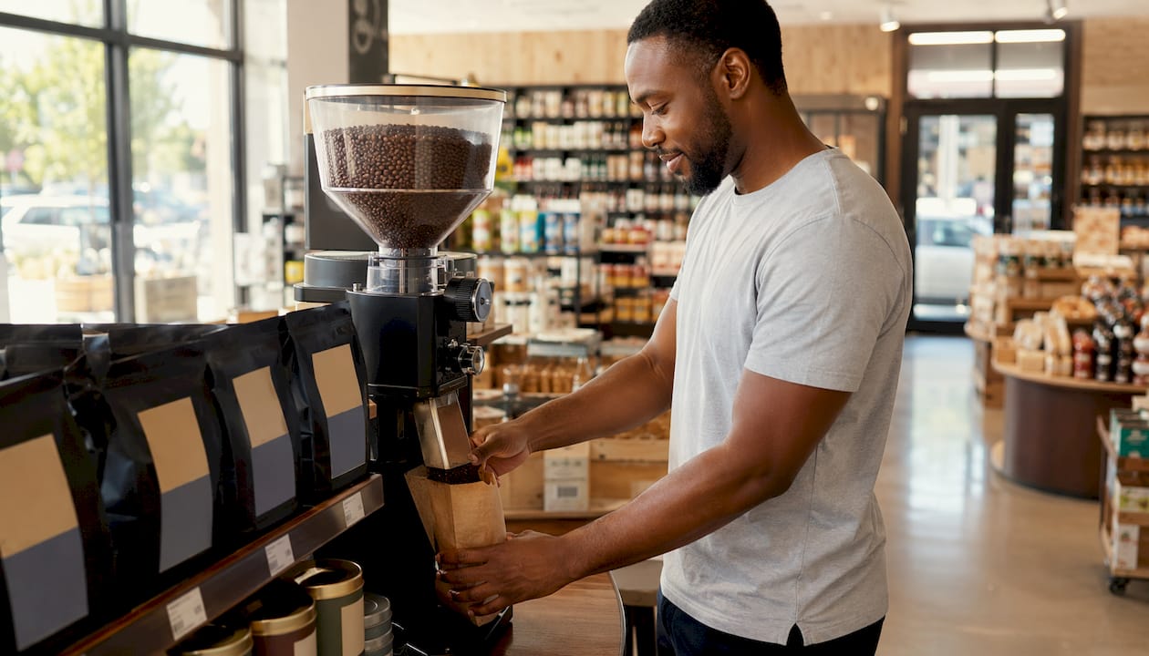 Person grinding coffee beans at grocery store