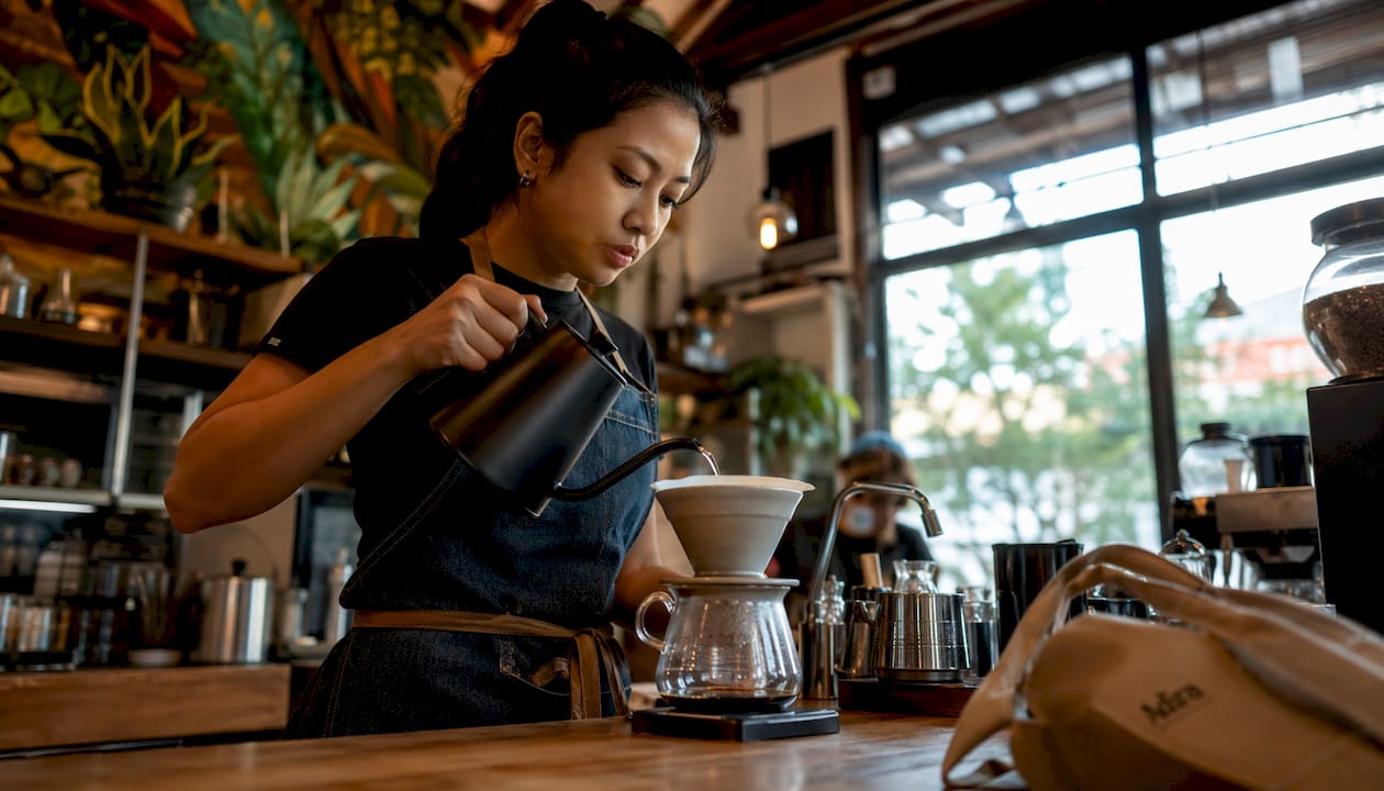 Barista pouring water over pour-over coffee