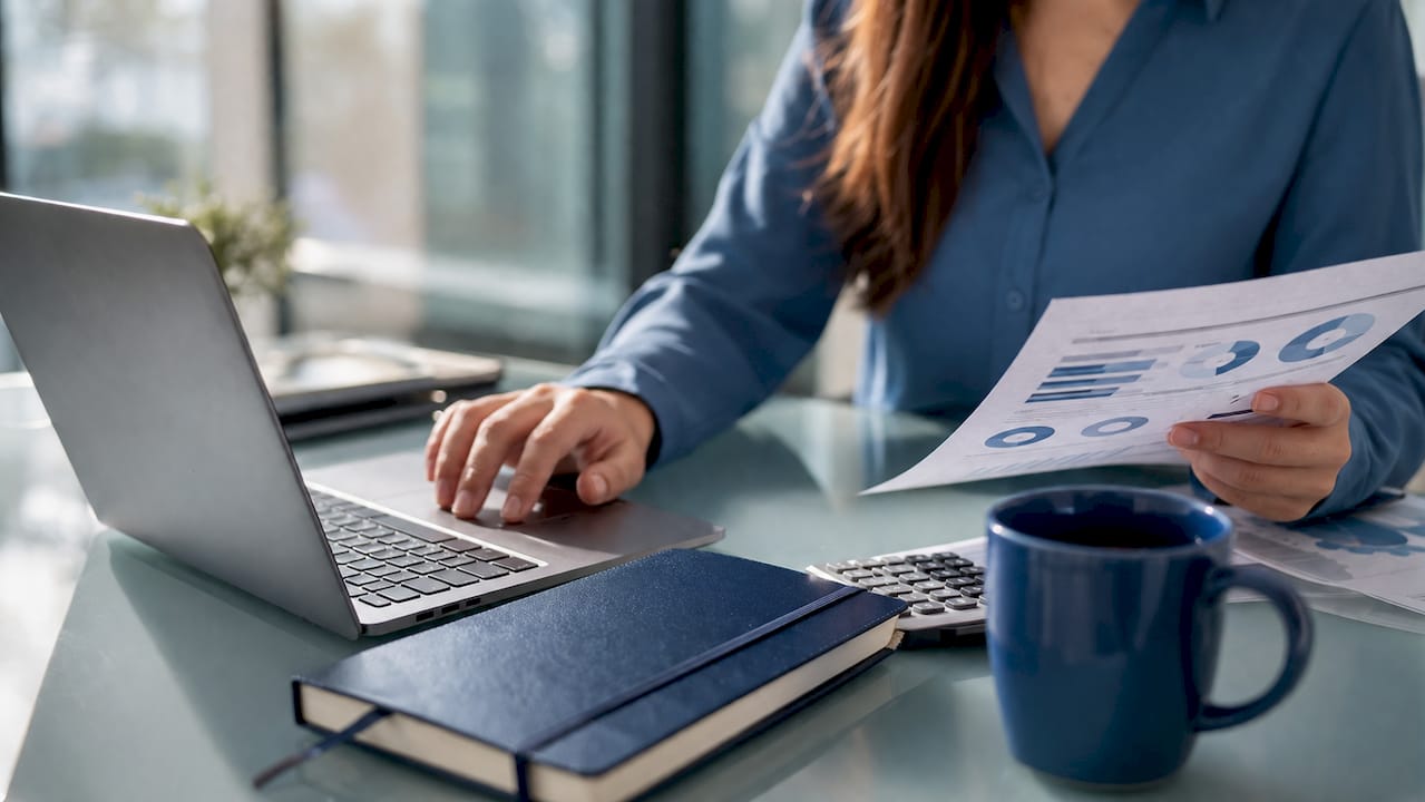 Payroll specialist working with spreadsheets and calculator