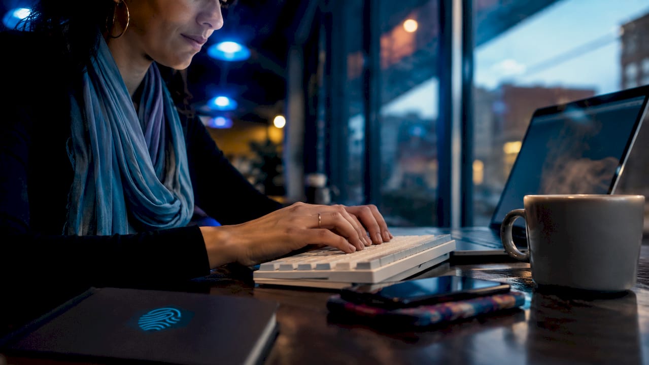 Hands typing PHP code in home office workspace