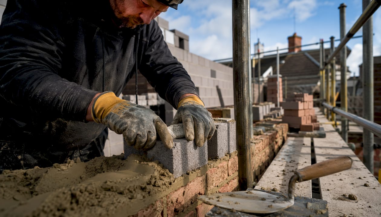 Builder laying bricks on extension site